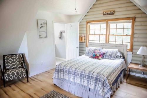 ein Schlafzimmer mit einem Bett, einem Stuhl und einem Fenster in der Unterkunft Brimstone Getaway w/Mountain View’s in Huntsville