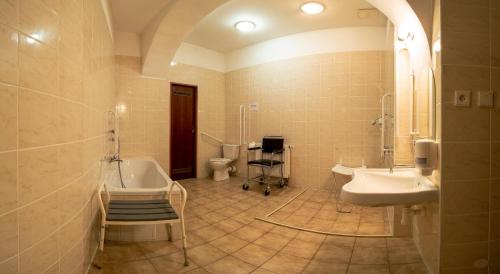 ein Badezimmer mit zwei Waschbecken, einer Badewanne und einem WC in der Unterkunft Klášter Hejnice - vzdělávací, konferenční a poutní dům in Hejnice