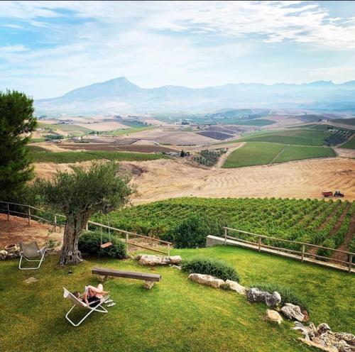 a view of a field with chairs and a bench at Agriturismo Antichi Granai in Calatafimi