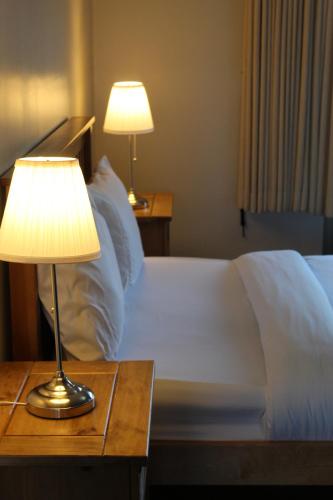 1 dormitorio con 1 cama con lámpara en una mesa en 1 Bed Studio Apartment- BHX, NEC, Resorts World- Johal Accommodation Ltd en Birmingham