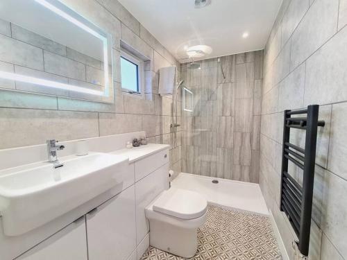 ein weißes Bad mit einem Waschbecken und einem WC in der Unterkunft Modern Luxury Apartment in Bishops Cleeve