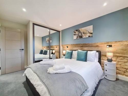ein großes Schlafzimmer mit 2 Betten und blauen Wänden in der Unterkunft Modern Luxury Apartment in Bishops Cleeve
