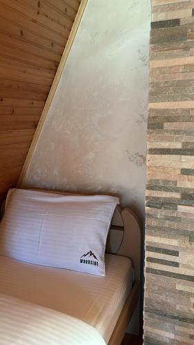 a small bed in a small room with a wall at WoodSide Žabljak in Žabljak