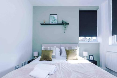 um quarto com uma cama branca e 2 almofadas em Spacious One-Bedroom Apartment in Saint Helens em Saint Helens