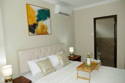 Un dormitorio con una gran cama blanca y una mesa en Vacation Family Dept 2 Via Costa American Consulate, en Guayaquil