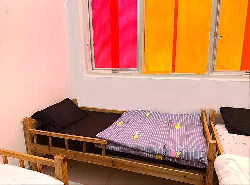Bett in einem Zimmer mit 2 Fenstern in der Unterkunft Corniche AD - For Males "Peaceful Bed Space" in Abu Dhabi