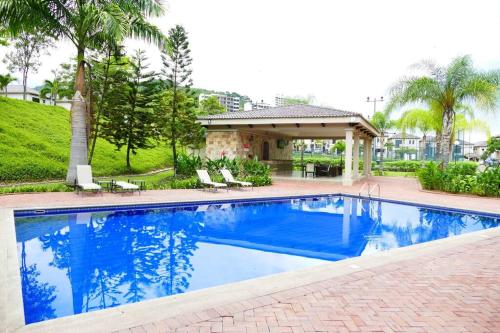 a large blue swimming pool in a yard at Vacation Family Dept 2 Via Costa American Consulate in Guayaquil