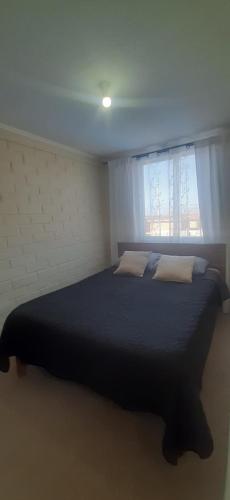 - une chambre avec un grand lit et une fenêtre dans l'établissement Linda y acogedora casa en Coquimbo, à Coquimbo