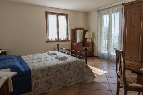 a bedroom with a bed and a table and chairs at La Maestà Tuscan Sun in Cortona