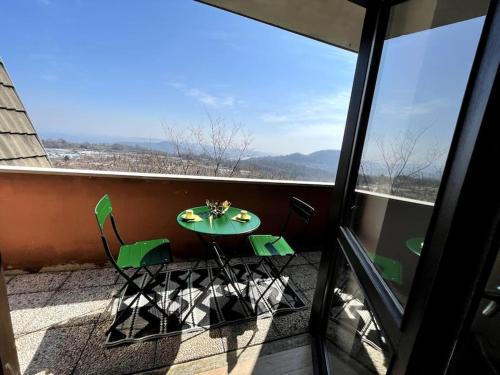 Attico da architetto luminoso sereno vista lago في Veruno: طاولة وكراسي على شرفة مطلة