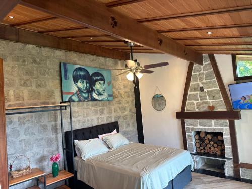 1 dormitorio con 1 cama y chimenea en Minas Em Marambaia en Río de Janeiro