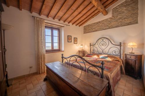 1 dormitorio con cama y mesa de madera en Agriturismo Antico Borgo Montacuto, en Pari