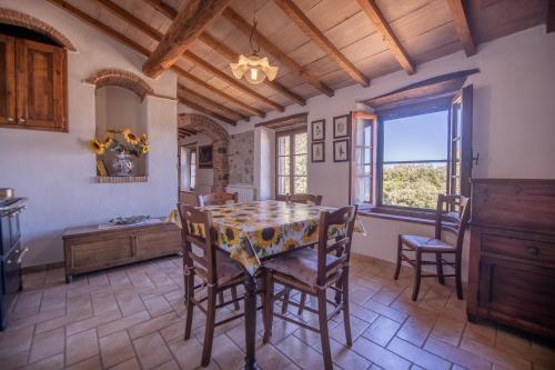 una cucina e una sala da pranzo con tavolo e sedie di Agriturismo Antico Borgo Montacuto a Pari