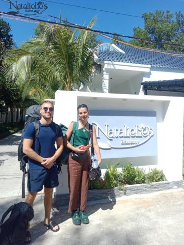 a man and a woman standing in front of a sign at NatalieLe's Homestay in Phu Quoc