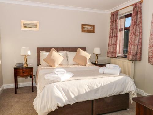 a bedroom with a bed with two towels on it at Molls Cottage in Nantwich