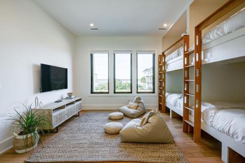 1 Schlafzimmer mit 2 Etagenbetten und einem TV in der Unterkunft White Lotus: Beachfront Edition in North Topsail Beach