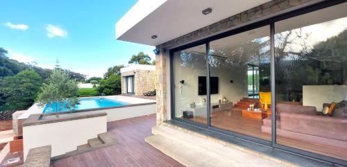a glass extension of a house with a swimming pool at Casa Azul Terceira Island Azores in Fonte Bastardo