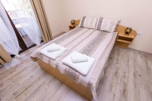 Un dormitorio con una cama con dos toallas encima. en Topalov, en Sandanski