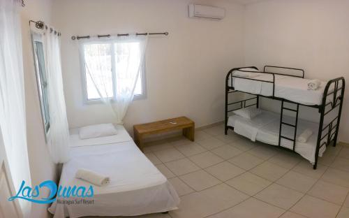 a room with two bunk beds and a window at Las Dunas Surf Resort in Aposentillo