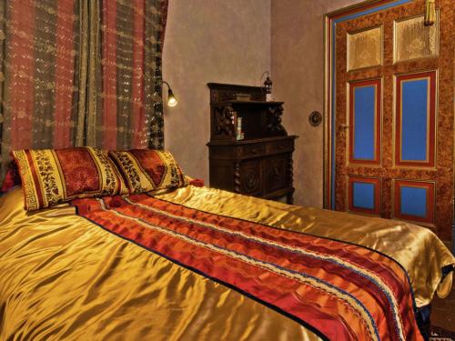 a bedroom with a bed with a gold comforter at Oude Pastorie en Dorpsschool Netze-Waldeck in Netze