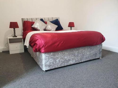 1 dormitorio con 1 cama con sábanas y almohadas rojas en Central Southampton Ocean Village, en Southampton