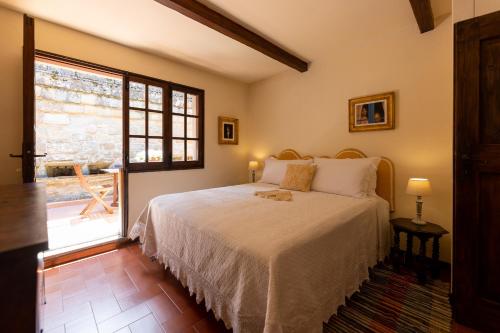 - une chambre avec un lit et une grande fenêtre dans l'établissement Castello e Borgo di Porciano, à Pratovecchio
