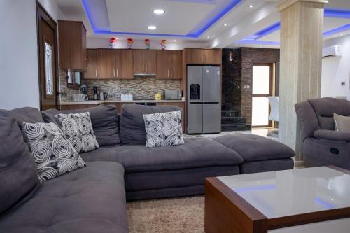 a living room with a couch and a kitchen at Luxury 5BR Private Villa with Pool - Paphos in Khlorakas