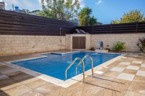 a swimming pool with blue water in a backyard at Luxury 5BR Private Villa with Pool - Paphos in Khlorakas
