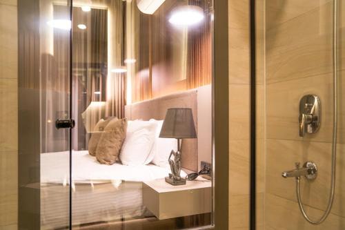 a bedroom with a bed with pillows and a lamp at MONALİSA HOTELS ÇANAKKALE in Hamidiye