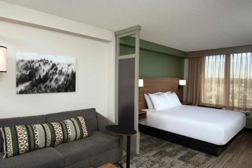 Habitación de hotel con cama y sofá en Hyatt Place Denver Tech Center, en Centennial