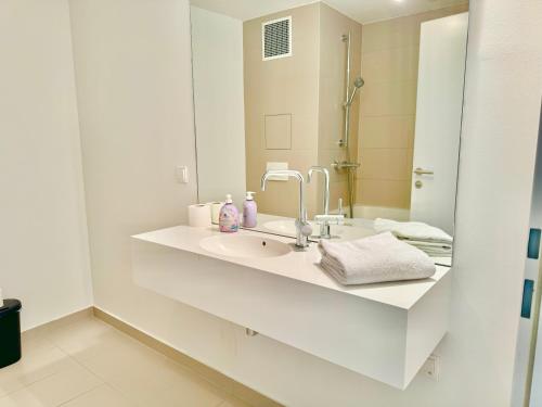 Baño blanco con lavabo y espejo en Modern 150 m2 Maisonette - Private Garden & Free Parking, en Viena