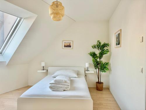 Un dormitorio blanco con una cama con toallas. en Modern 150 m2 Maisonette - Private Garden & Free Parking, en Viena