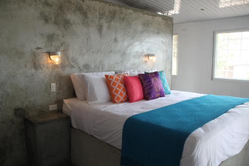 a bedroom with a large bed with colorful pillows at La Maracuya Panama in Playa Coronado