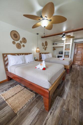 a bedroom with two beds and a ceiling fan at Ocean Tide Beach Resort in San Pedro