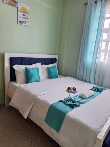 a bedroom with two beds with blue and white pillows at Wema stays air Bnb in Naivasha