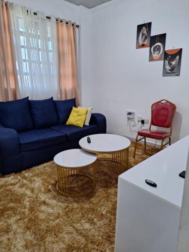 a living room with a blue couch and two tables at Wema stays air Bnb in Naivasha