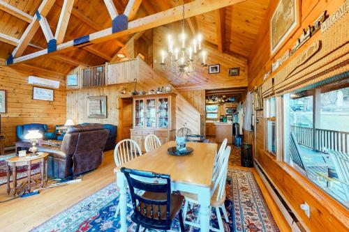 a dining room and living room with a table and chairs at Lake Bomoseen Log Cabin in Bomoseen