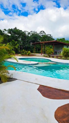 a swimming pool with blue water in a resort at Confort Arenal in Fortuna