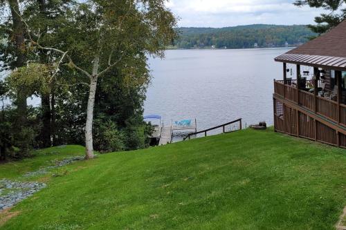 a house on a hill next to a lake at Lake Bomoseen Log Cabin in Bomoseen