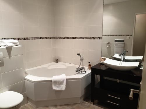 a bathroom with a tub and a toilet and a sink at Hostellerie Belle Rive in Gagnac-sur-Cère