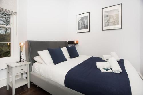 Schlafzimmer mit einem Bett mit blauen und weißen Kissen in der Unterkunft River View House Cleveland Bridge in Bath