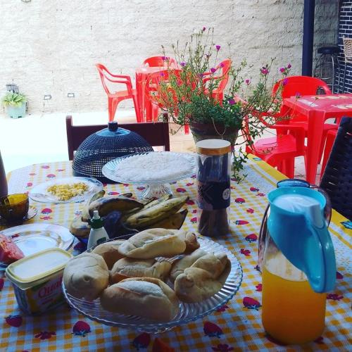 a table with a plate of food and orange juice at POUSADA MARIA FLOR in Caucaia