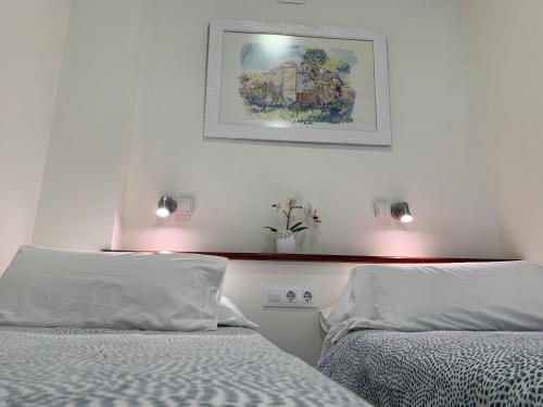 1 dormitorio con 2 camas y una foto en la pared en Apartamento La Vasca en El Puerto de Santa María