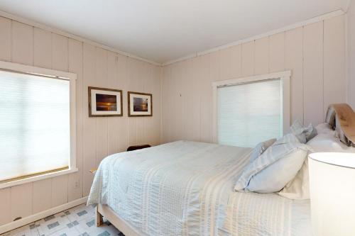 1 dormitorio blanco con 1 cama y 2 ventanas en Beneath the Banyans, en Bonita Springs