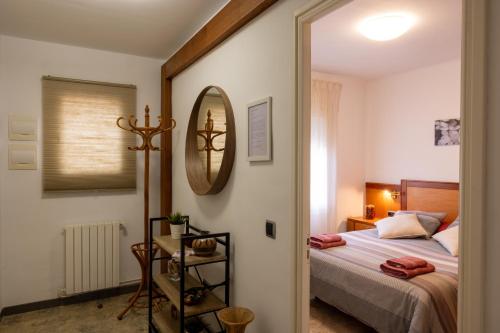 - une chambre avec un lit et un miroir dans l'établissement Ca la Pauleta, à Sant Hilari Sacalm