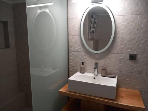 a bathroom with a white sink and a mirror at Marika's Place in Néa Péramos