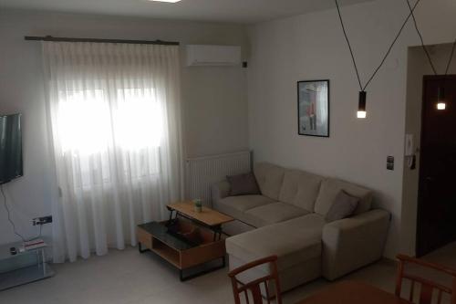 a living room with a couch and a table at Marika's Place in Néa Péramos