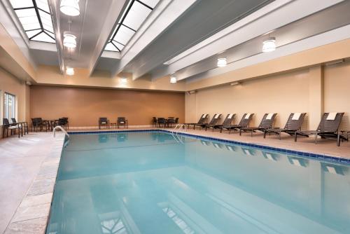 a large swimming pool with chairs in a building at Hyatt Place Denver Tech Center in Centennial