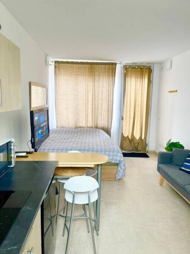 Cette chambre comprend un lit et un bureau avec une table. dans l'établissement GOLDEN HOUR Studio Marittimo, à Palma de Majorque