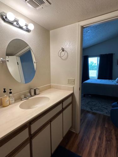 a bathroom with a sink and a mirror and a bed at Cozy remodeled-condo near TUC Airport & Downtown in Tucson